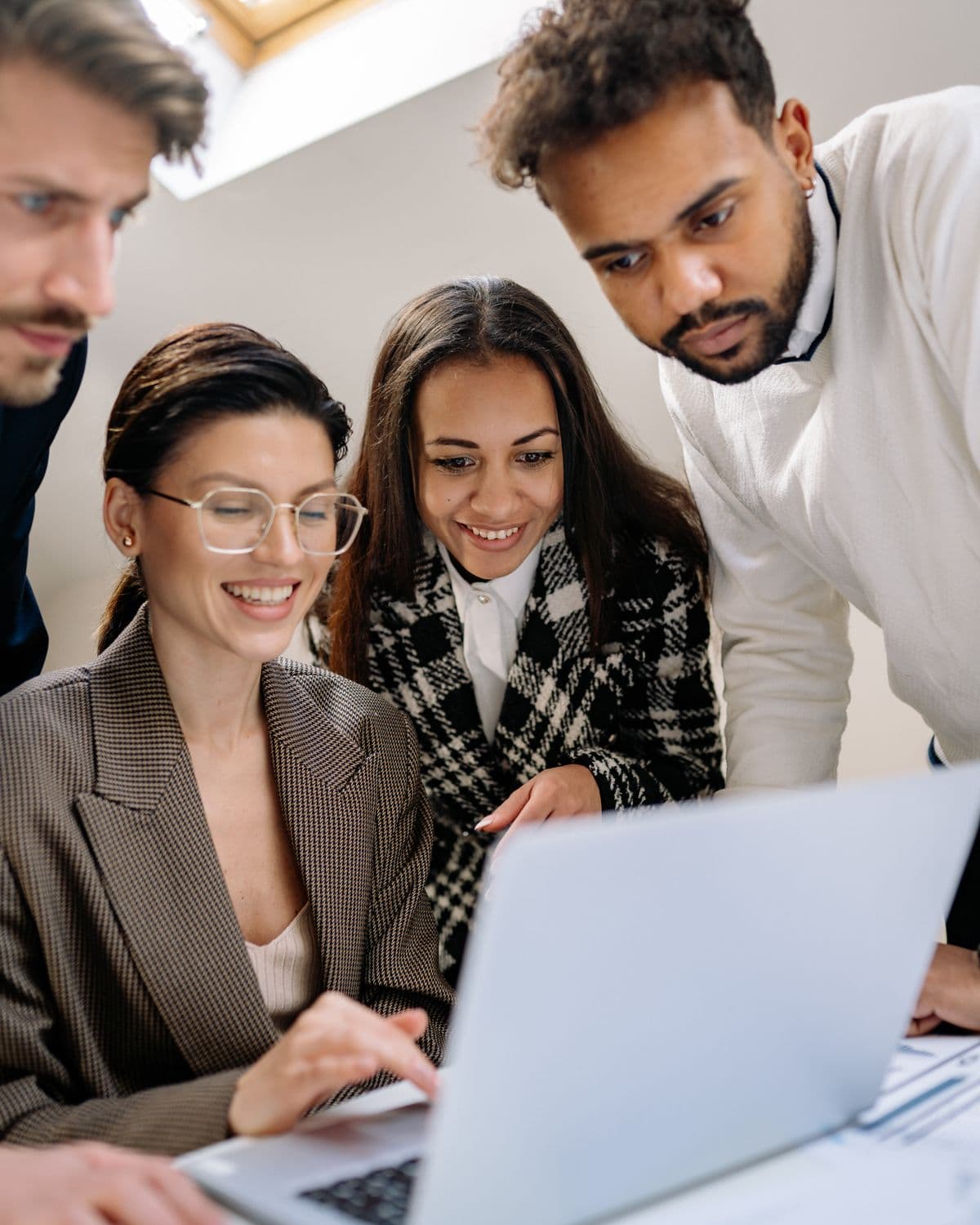 Colleagues reviewing work together at a laptop