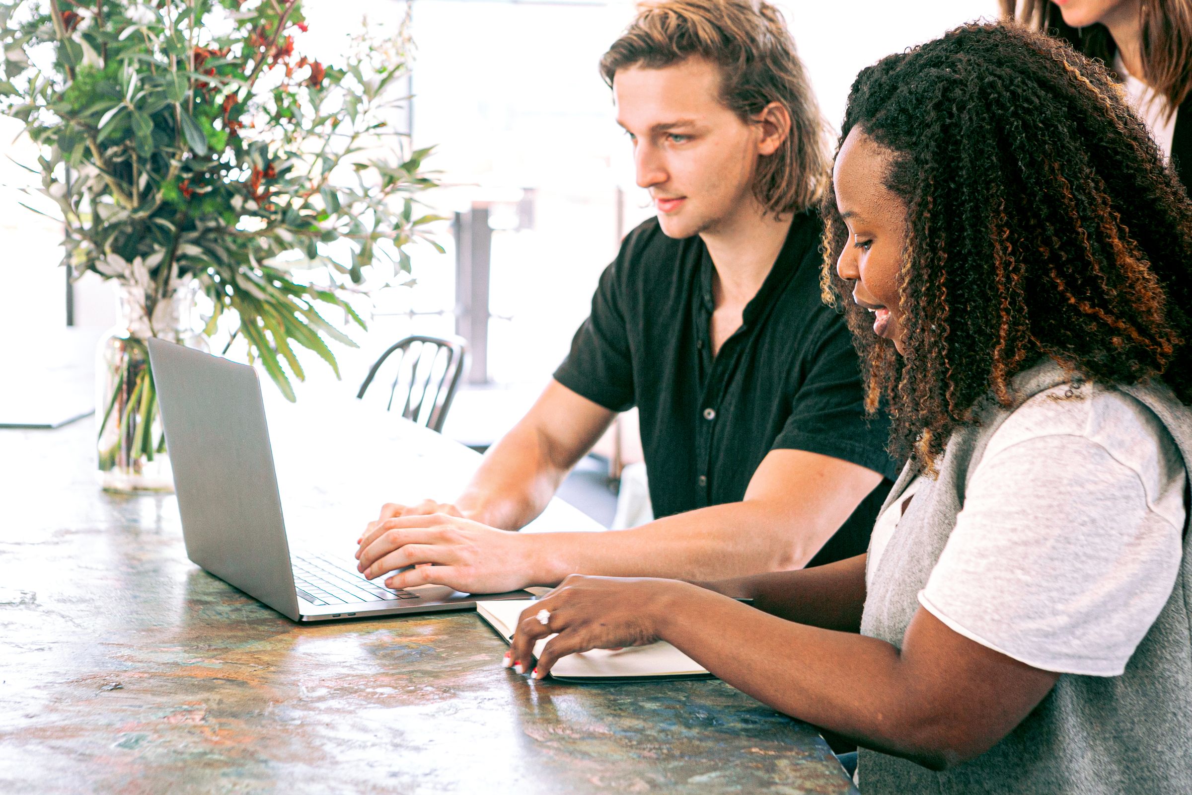 Two marketing colleagues working through their operations at a laptop
