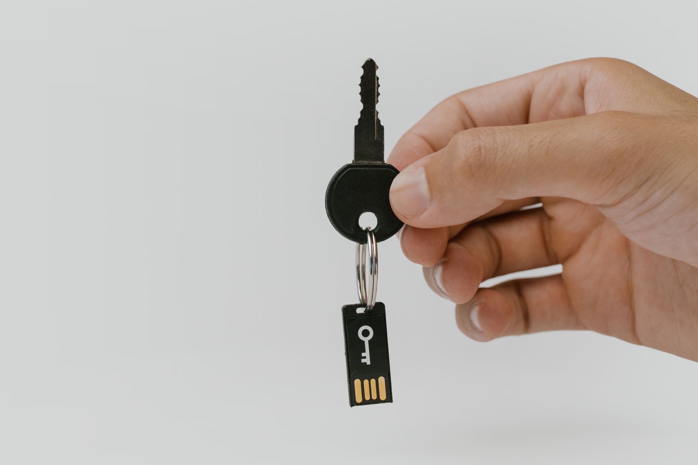 Hand holding a key with a USB drive key fob