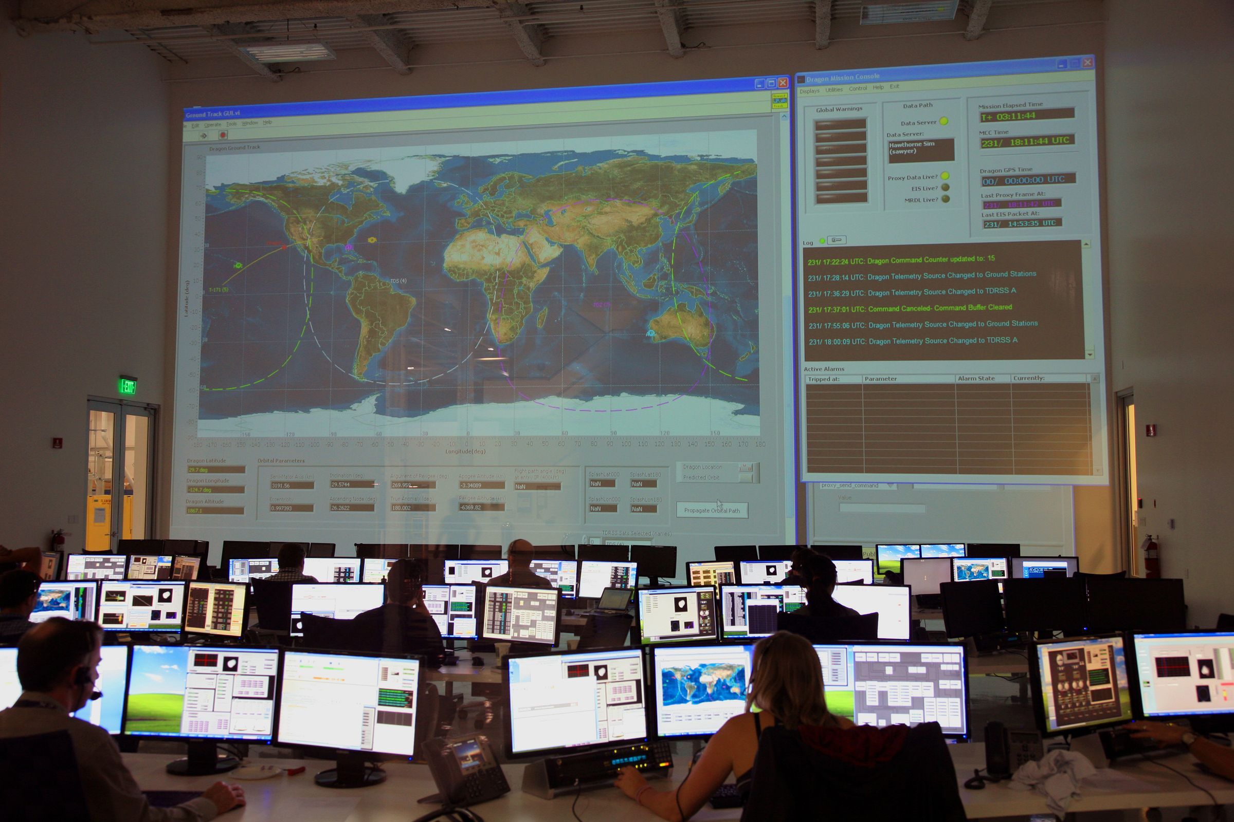 Operations team at their workstations below a large live display in a monitoring centre