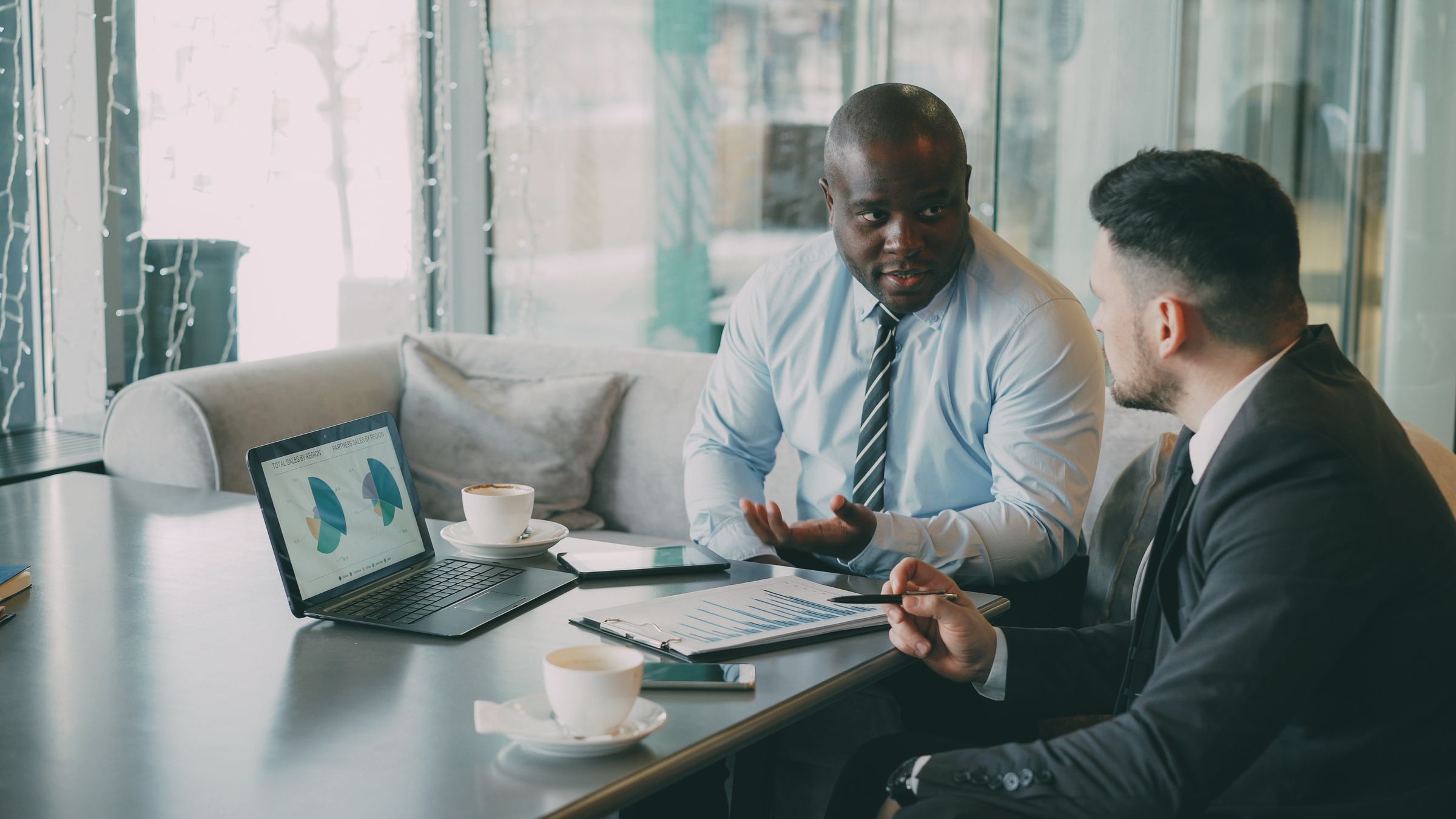 Sales leaders reviewing pipeline data on a laptop in a bright office